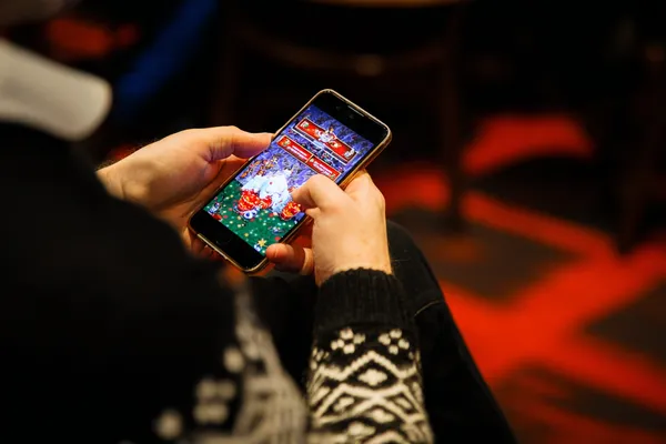 A man focused on his laptop with live stats in the background, highlighting the dedicated sports and gaming features of the 520JL mobile app.