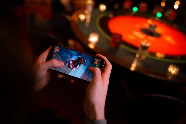 A player using their smartphone during a festive local event, representing 520JL’s fully mobile-friendly casino.